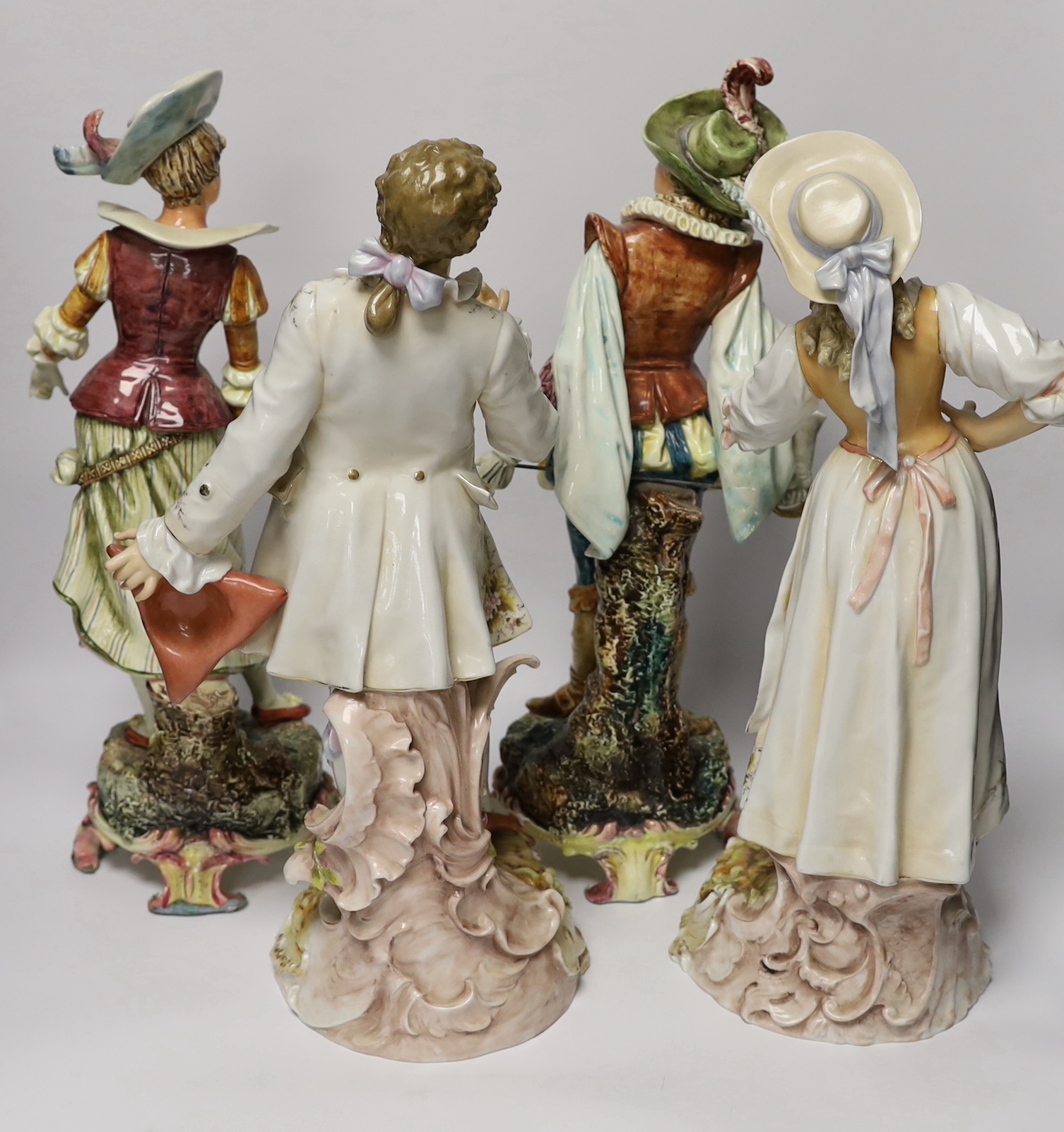 A pair of Volkstedt porcelain figures and a pair continental earthenware figures, 42cm